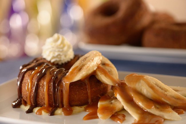 Be Our Guest Breakfast: croissant donut topped with bananas, caramel sauce, chocolate ganache, and whipped cream.